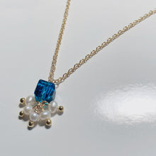 Load image into Gallery viewer, A pair of stud earrings featuring 6mm sugar blue Austrian crystal cubes paired with 2-3mm freshwater baroque pearls, showcasing a whimsical and elegant design.