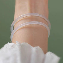 Load image into Gallery viewer, A thin, small bangle made of translucent natural white agate gemstone, available in 54mm, 56mm, and 58mm sizes, showcasing a delicate and sophisticated glow.