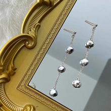 Load image into Gallery viewer, A pair of earrings featuring 4mm black peacock baroque natural pearls, wire-wrapped and dangling from a 10cm drop, designed for a sophisticated look
