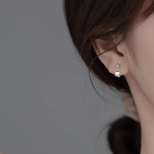 Load image into Gallery viewer, Tiny stud earrings made of surgical steel, featuring 6mm and 8mm clear AB rainbow sugar cube beads, showcasing a minimalist design with a pop of color.