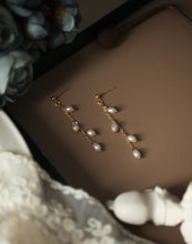 Load image into Gallery viewer, 18K gold plated or surgical steel stud earrings with 4mm oval rice pearls in a flora style design, perfect for adding a touch of sophistication to any outfit.