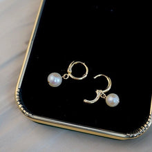 Load image into Gallery viewer, 18K gold plated huggie earrings with off-round AAA-grade 7mm freshwater pearls, perfect for adding a touch of elegance to any outfit.