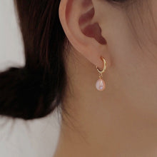 Load image into Gallery viewer, Hoop earrings plated with 18K gold, featuring 5-6mm AAA oval light pearls in white, peach, and purple colors, with a lever back huggie style.