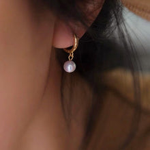 Load image into Gallery viewer, 18K gold plated huggie earrings with off-round AAA-grade 7mm freshwater pearls, perfect for adding a touch of elegance to any outfit.