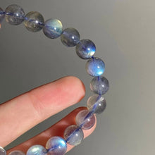 Load image into Gallery viewer, A bracelet made of AAA labradorite round beads in 6mm and 8mm sizes, showcasing stunning iridescence and color play, with a stretchy design for a comfortable fit.