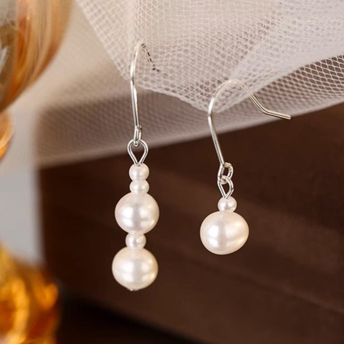 Asymmetrical surgical steel dangle earrings with 3mm and 6mm freshwater pearls, hypoallergenic and elegant.