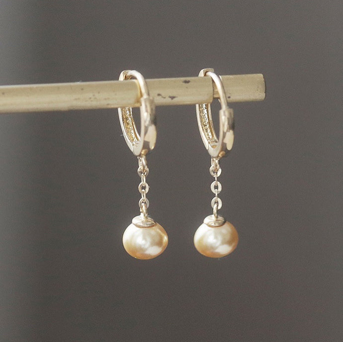 18K gold-plated surgical steel hoop earrings with 16mm hoop and 8mm freshwater button pearls in peach. Total length of 3.5-4cm. Elegantly designed for any occasion.