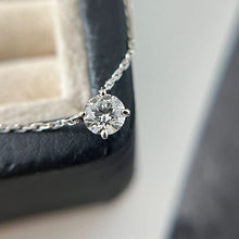 Load image into Gallery viewer, A necklace featuring a 6.5mm round cut moissanite gemstone, suspended from a delicate chain, showcasing exceptional brilliance and elegance.
