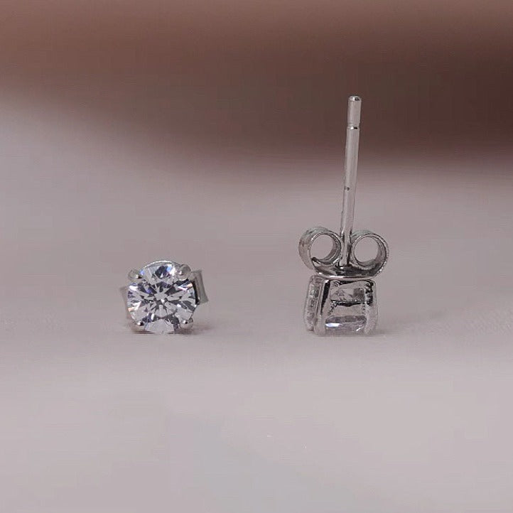 Pair of sterling silver stud earrings featuring 3/4/5mm moissanite stones in prong settings