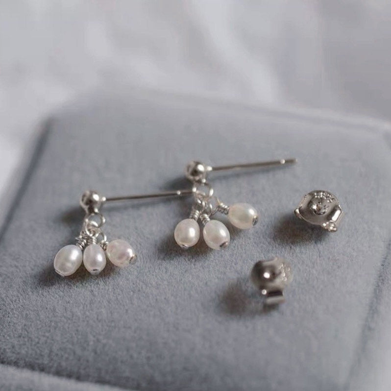 A pair of 18K Gold Plated or surgical steel stud earrings with AAA 4-5mm small oval natural pearls.