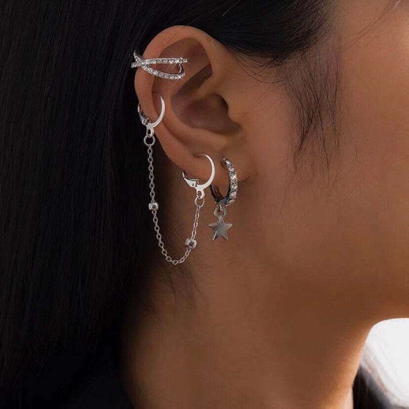 A pair of silver hoop earrings with a chain of moving beads, measuring 5cm in length. The earrings have a punk-inspired design with a double-piercing style.