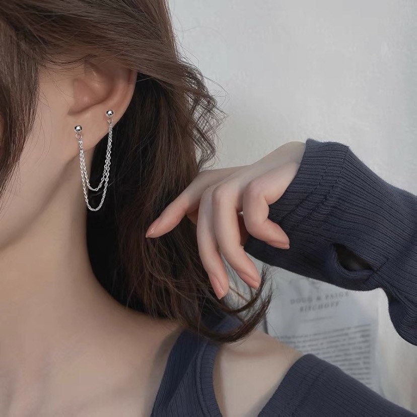 Image of a pair of Korean-inspired double-layered double piercing earrings, featuring hypoallergenic steel studs with delicate 1.2x1mm chains, creating a trendy 5cm drop.