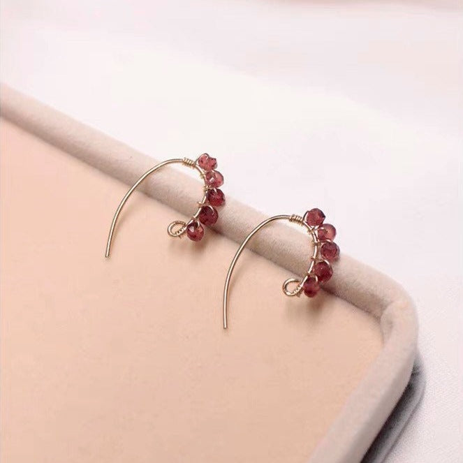 A pair of 18K Gold Plated steel ear wire earrings with 4mm faceted garnet beads in a floral wire-wrapped design.