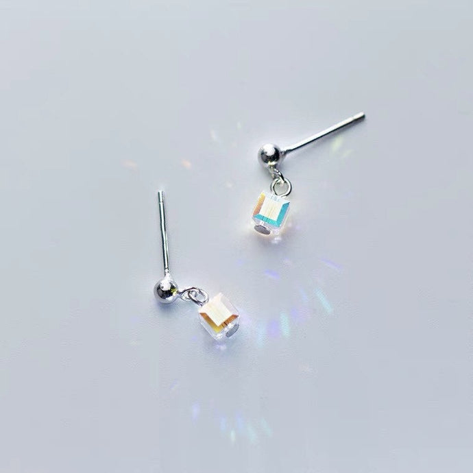 Tiny stud earrings made of surgical steel, featuring 6mm and 8mm clear AB rainbow sugar cube beads, showcasing a minimalist design with a pop of color.