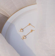 Load image into Gallery viewer, 18K gold plated or steel dainty stud earrings with 3-4mm natural pearls and a chain, perfect for adding a touch of sophistication to any outfit.
