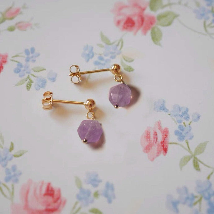 A pair of 18K Gold Plated stud earrings with star-shaped, diamond-cut natural faceted lavender amethyst gemstones.