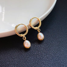 Load image into Gallery viewer, Hoop earrings plated with 18K gold, featuring 5-6mm AAA oval light pearls in white, peach, and purple colors, with a lever back huggie style.
