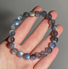 Load image into Gallery viewer, A bracelet made of AAA labradorite round beads in 6mm and 8mm sizes, showcasing stunning iridescence and color play, with a stretchy design for a comfortable fit.
