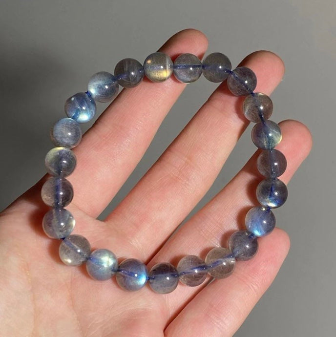 A bracelet made of AAA labradorite round beads in 6mm and 8mm sizes, showcasing stunning iridescence and color play, with a stretchy design for a comfortable fit.